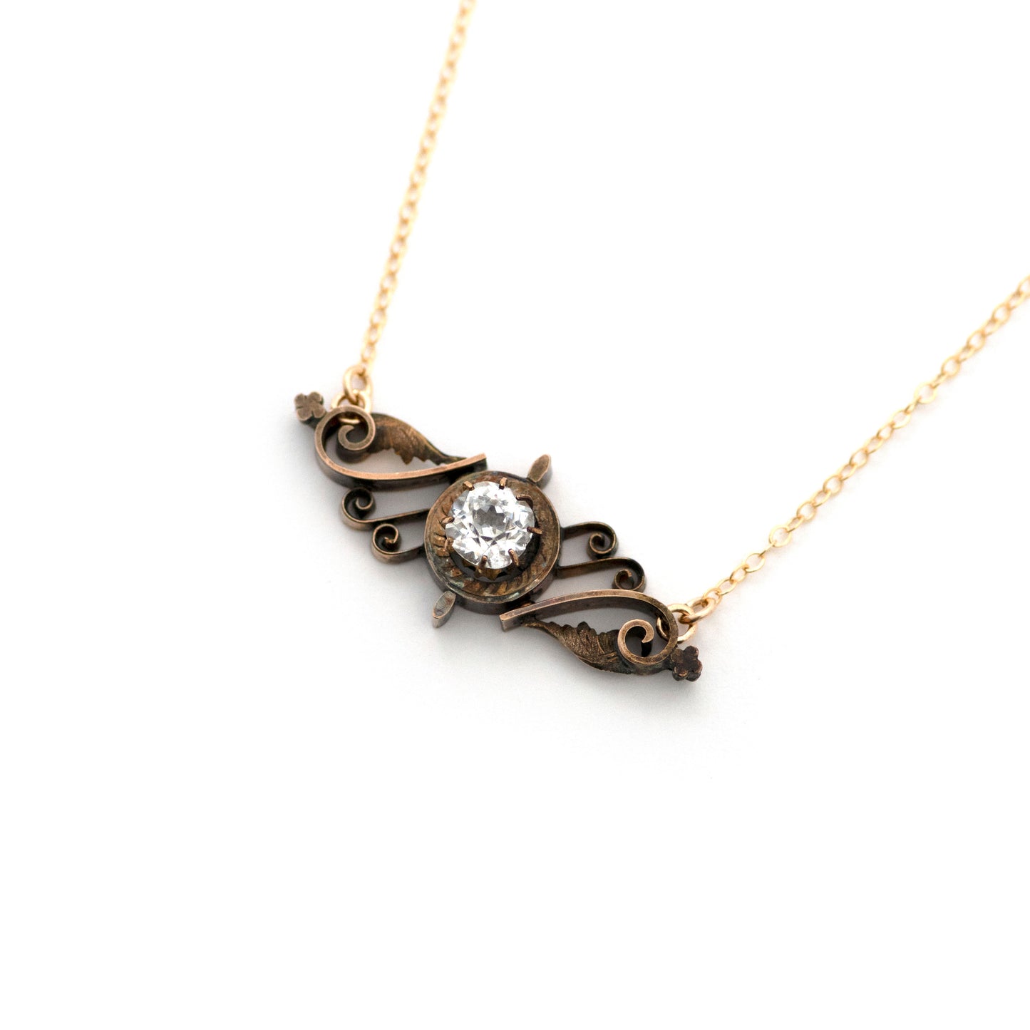 This one-of-a-kind conversion necklace is made up of: Brass Victorian brooch pendant from the late 1800s with hand tooled details. Pendant measures 1" wide. Clear paste rhinestone is bright and sparkly.