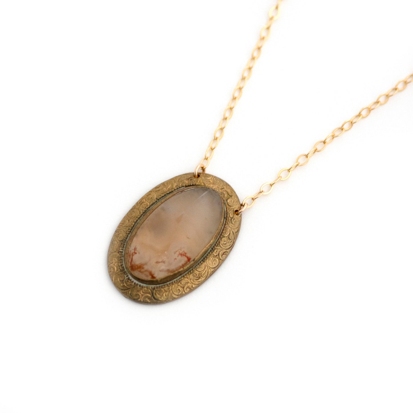 Gold filled Victorian brooch pendant from the late 1800s with hand tooled details, featuring a slab of red moss agate that is full of mystery.