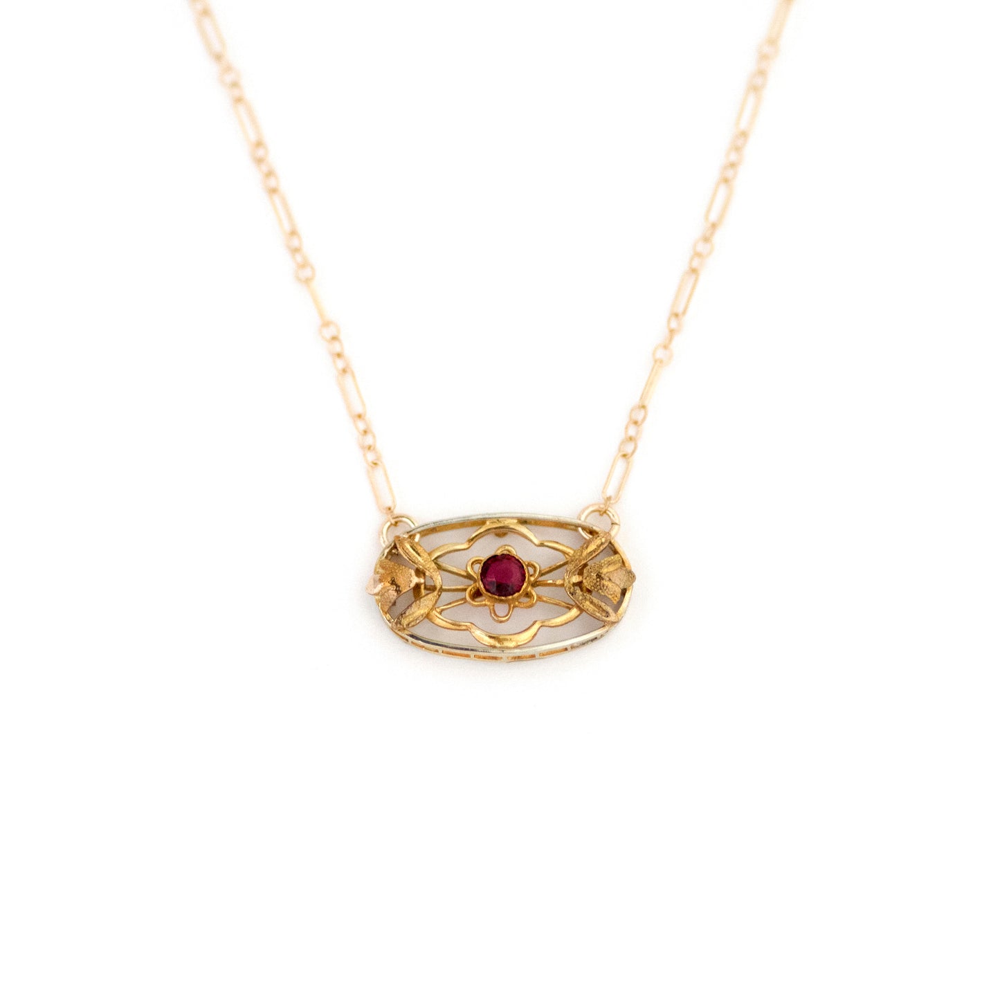 This one-of-a-kind conversion necklace is made up of: Gold filled Victorian brooch pendant from the late 1800s with hand tooled floral tulip details and a ruby red paste stone in its center.