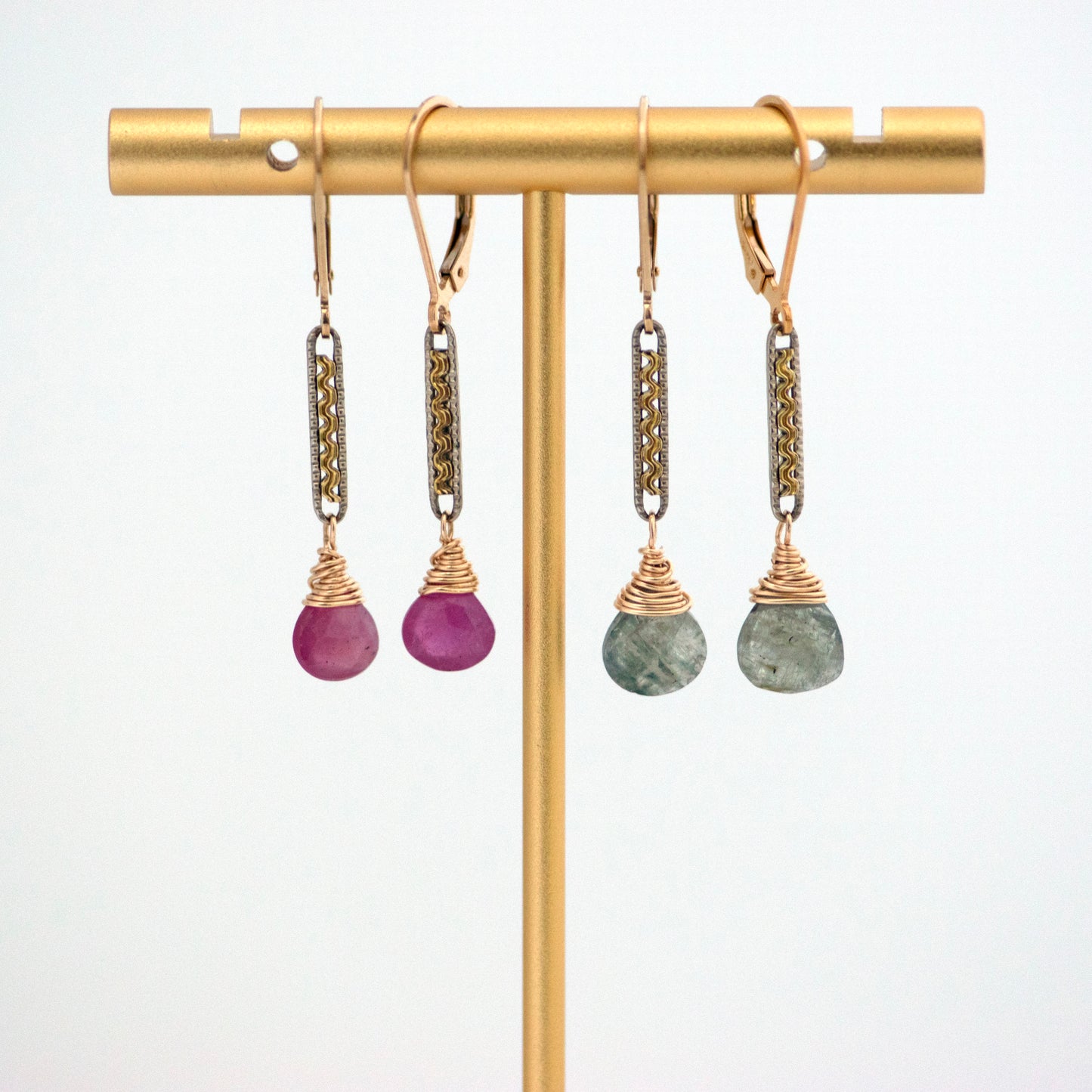 Two pairs of antique conversion earrings main links froade up of: Gold filled and silver tone Edwardian watch chm the early 1900s with ruby drops on one and moss aquamarine drops on the second pair..