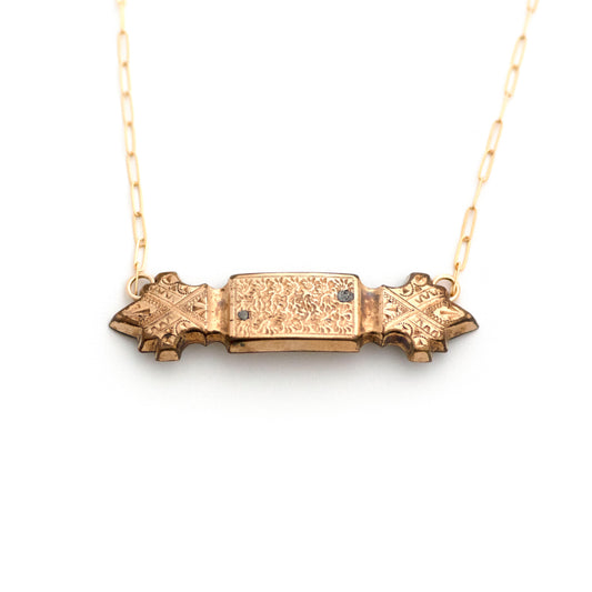 Gold filled Victorian bar pin pendant from the late 1800s with hand tooled details. Pendant measures 2" wide. Bar pendant has a mild convex curve from the front. Two solder marks are indications of a life well lived.