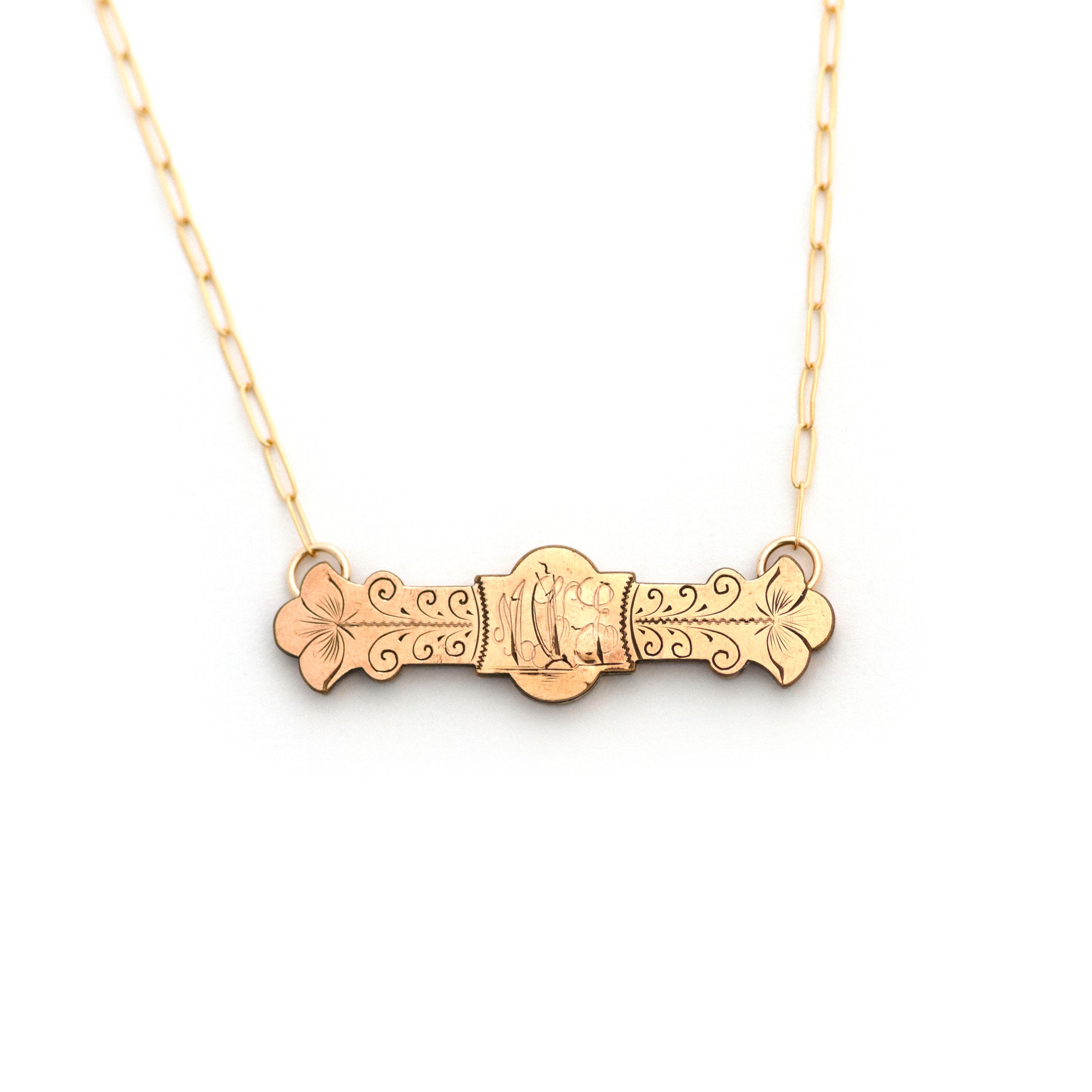 This antique conversion necklace is made up of:  Gold filled Victorian bar pin pendant from the late 1800s with hand engraved  details. Initials of MKE or MEK appear to be engraved over a landscape scene with a ship sailing over the open water and into the sunset.