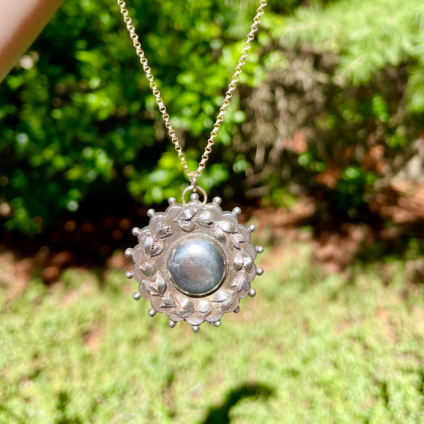 Antique Victorian Sterling Leaves Brooch Necklace hanging in the sunlight