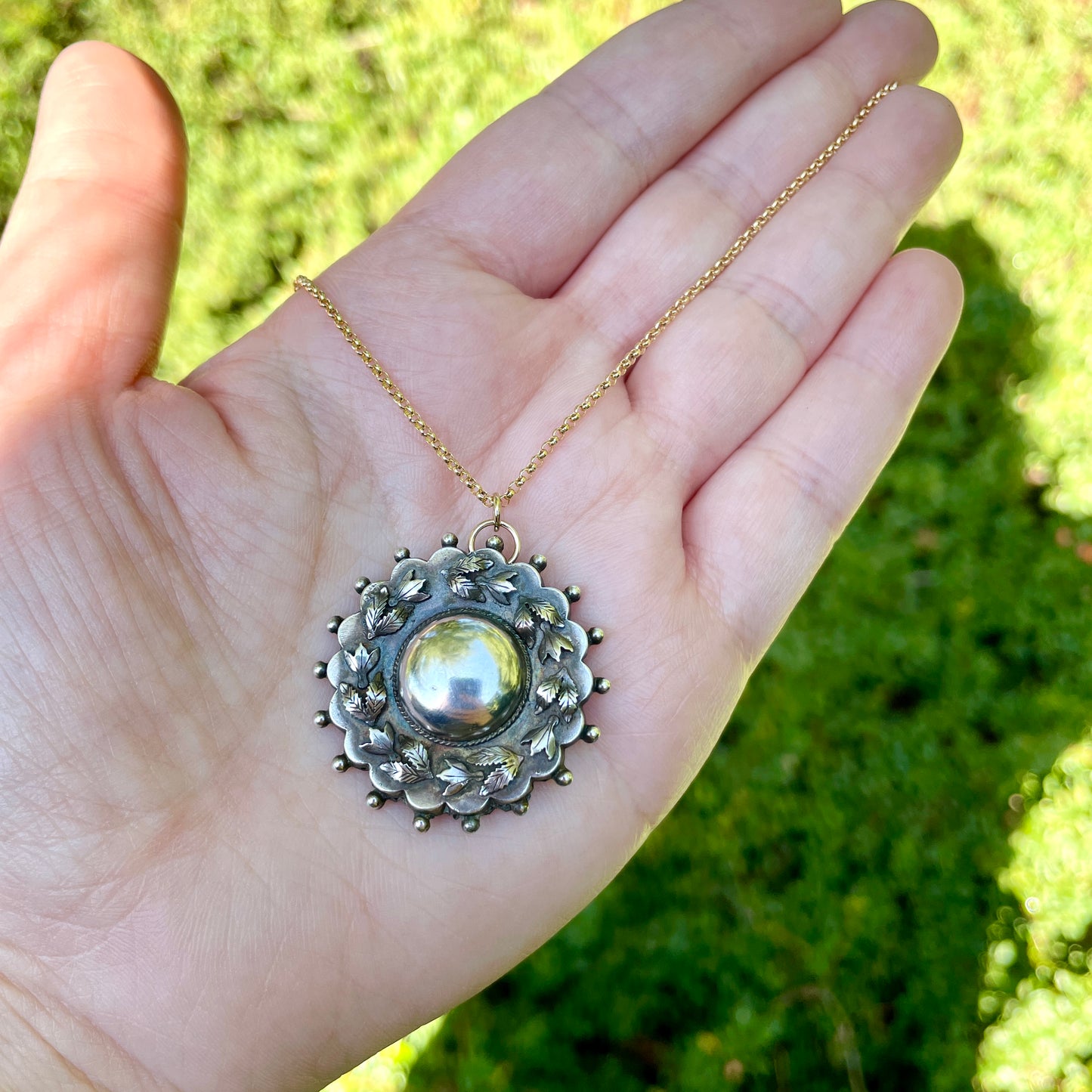 Antique Victorian Sterling Leaves Brooch Necklace held in the palm of the hand in the shade