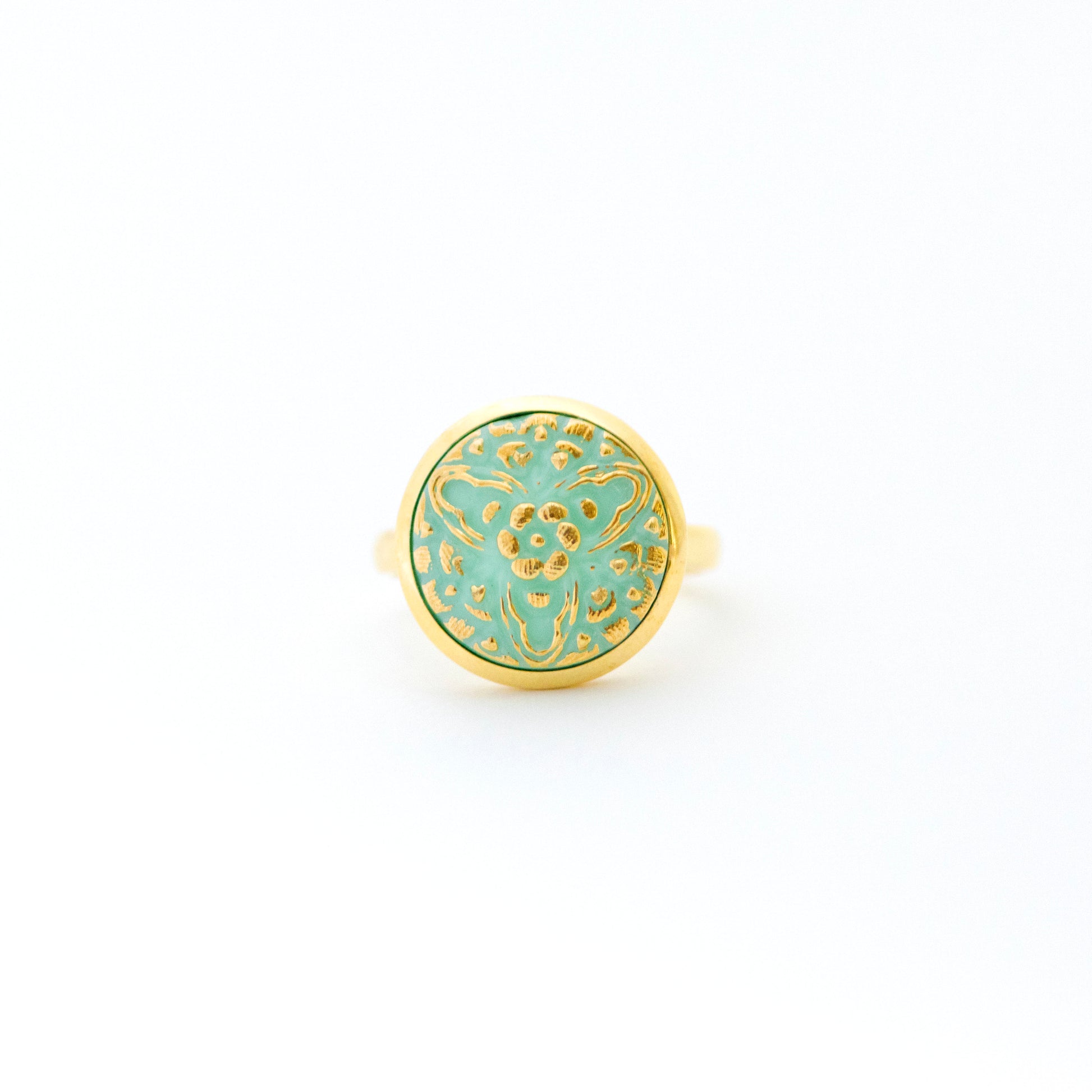 Light turquoise uranium glass Czech glass button with 3 point floral design.  Uranium glass button contains 2% uranium dioxide. This small amount in the glass allows it to fluoresce (glow) green under a black light and is also safe to wear.  Set in gold over sterling silver.