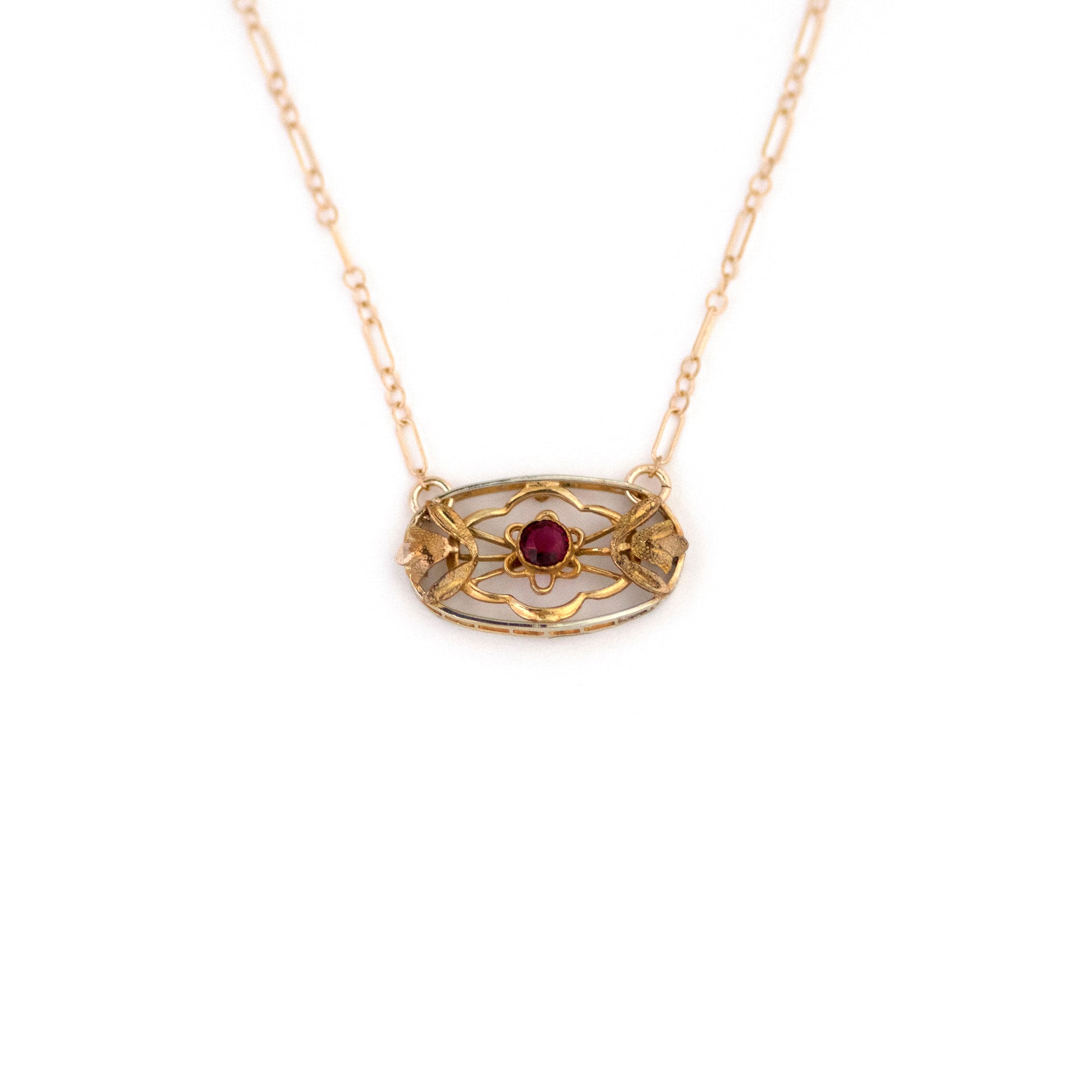 This one-of-a-kind conversion necklace is made up of:  Gold filled Victorian brooch pendant from the late 1800s with hand tooled floral tulip details and a ruby red paste stone in its center. 