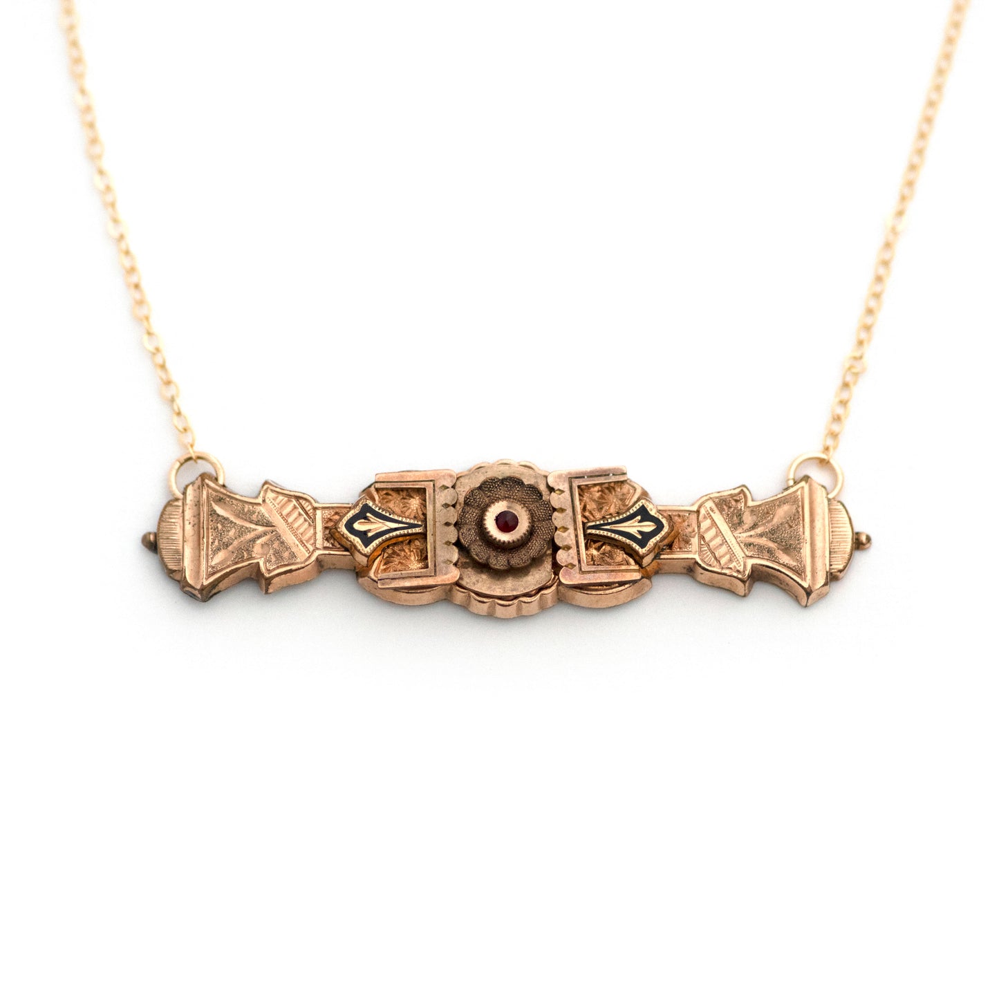 This one-of-a-kind conversion necklace is made up of:  Gold filled Victorian bar pin pendant from the late 1800s with hand tooled details, black enamel (taille d'epargne) and a Bohemian garnet. Pendant measures 2.4" wide.