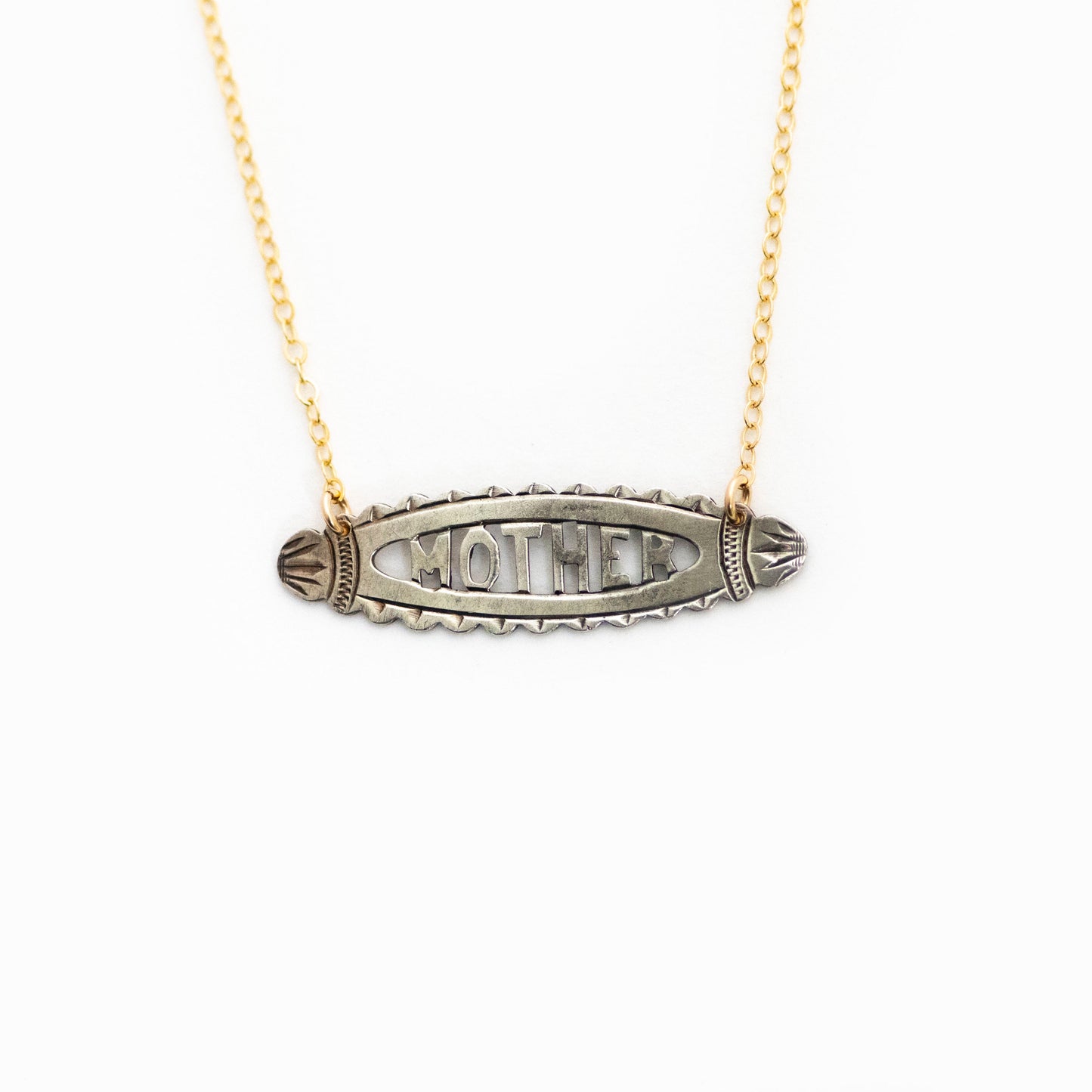 This antique conversion necklace is made up of:  Sterling silver Victorian bar pin pendant from the late 1800s with hand fabricated details depicting the word "MOTHER". Hanging straight down from a 14k gold filled cable chain.