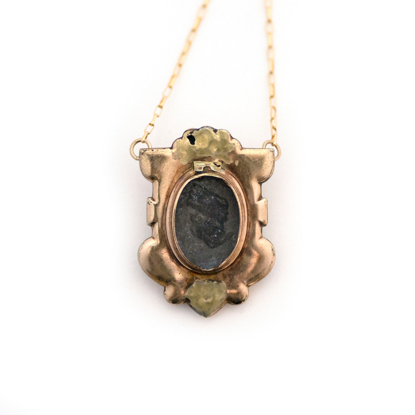 The back of Antique Victorian Blue Paste Shield Necklace shows a hidden locket on the back where the glass cover is missing.
