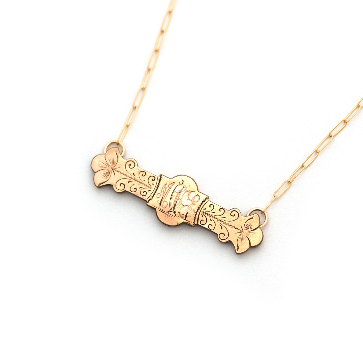 This antique conversion necklace is made up of:  Gold filled Victorian bar pin pendant from the late 1800s with hand engraved  details. Initials of MKE or MEK appear to be engraved over a landscape scene with a ship sailing over the open water and into the sunset.